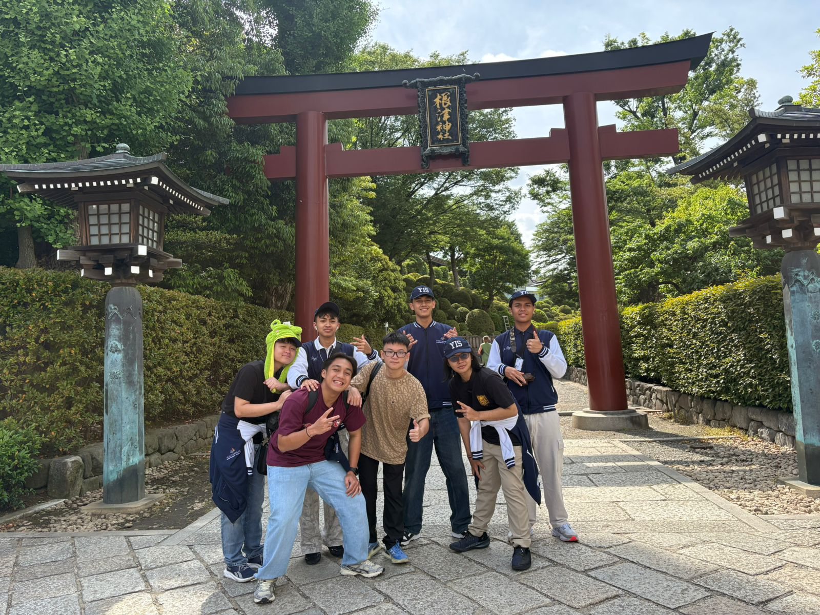 YIS students standing under the red torii gate at Nezu Shrine