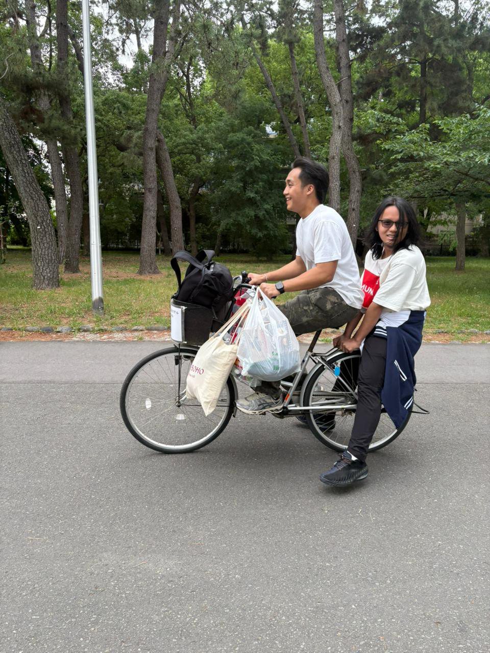 Radif carrying bags and giving Vincent a bicycle lift near the hotel