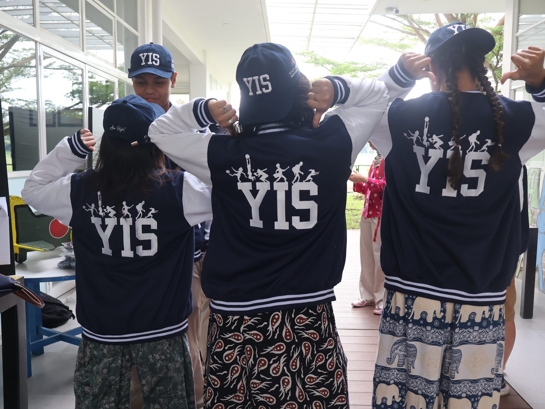 Students showing the YIS logo on their journey jackets